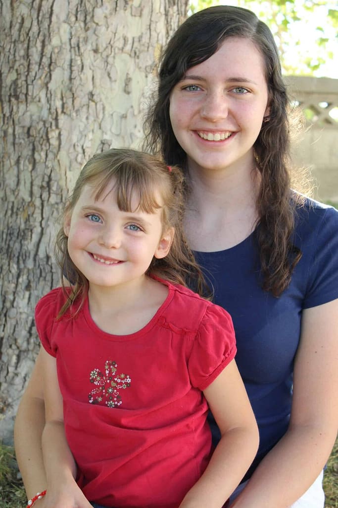 two sisters wearing fourth of july colors posing for picture
