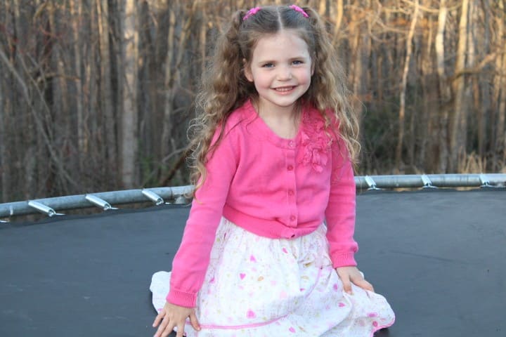 little girl sitting on the trampoline.