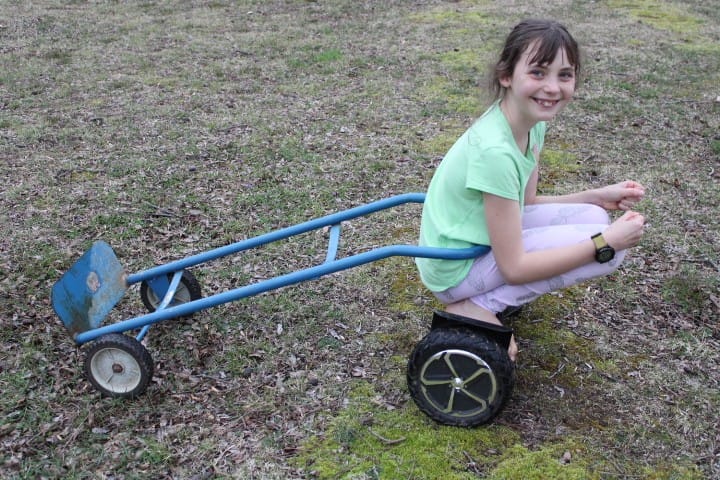 girl on hoverboard pulling dolley
