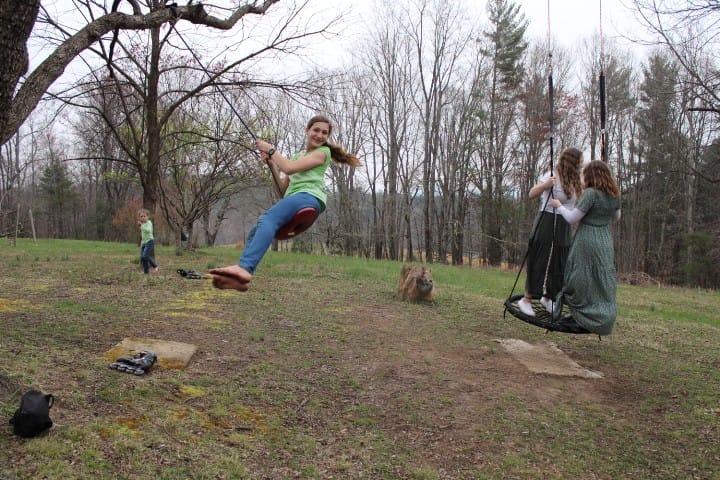 kids playing on swings in yard