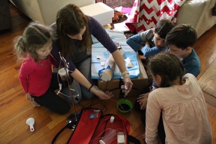 kids practicing blood draws on a fake arm