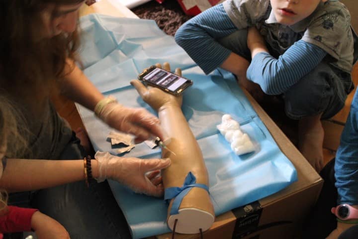 17 year old does a needle stick on a fake arm while little kids watch