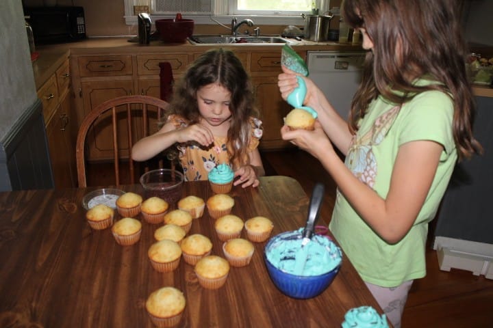 2 girls frost cupcakes