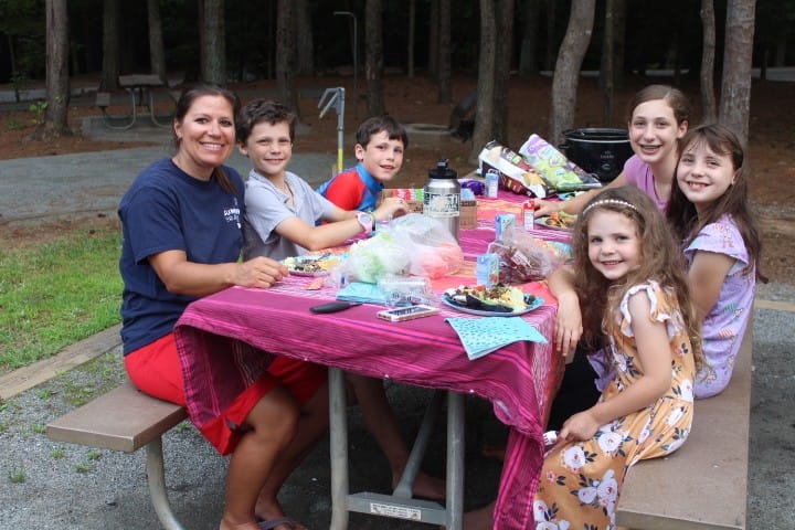 family eating taco salad at a picnic table at Lake Norman