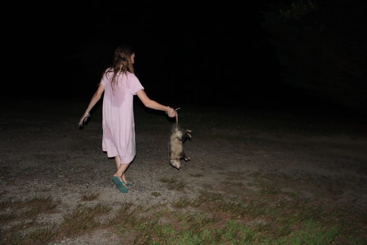 13 year old girl throwing a dead possum into the woods