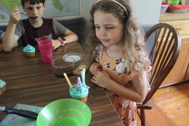 6 year old about to blow her candles out on a cupcake