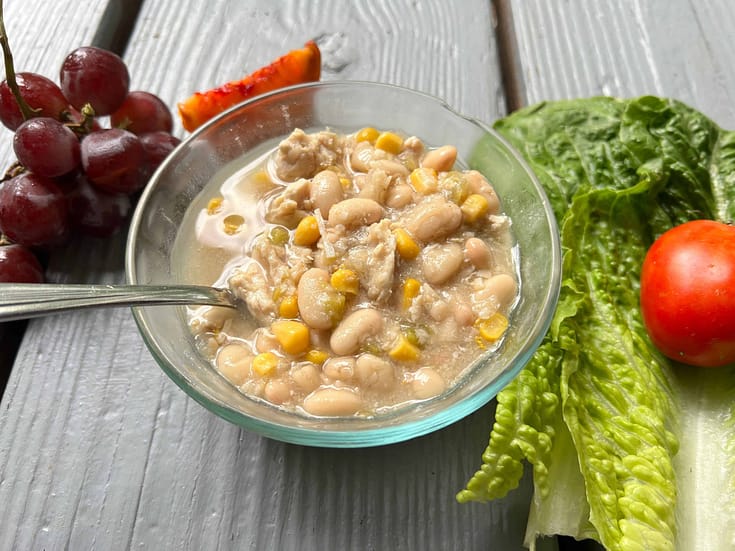 bowl of white chicken chili with lettuce and grapes
