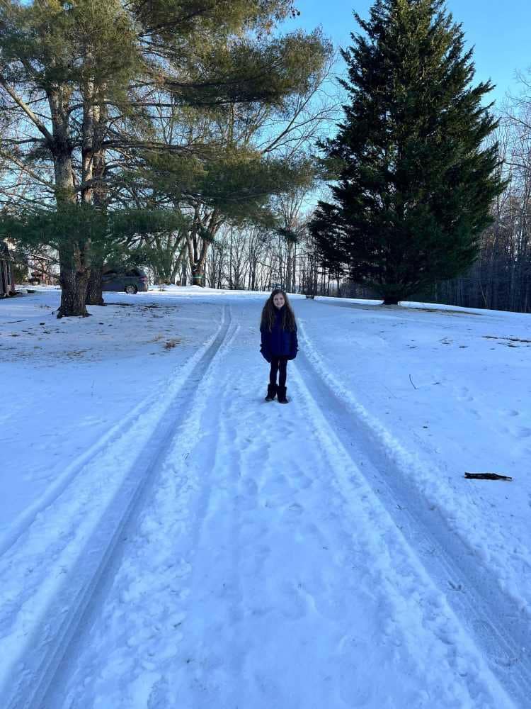girl in snow covered driveway
