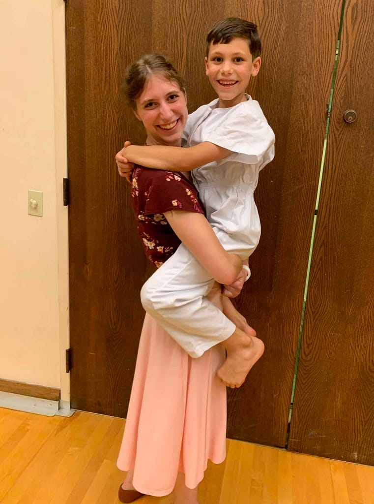 sister holding brother at his baptism