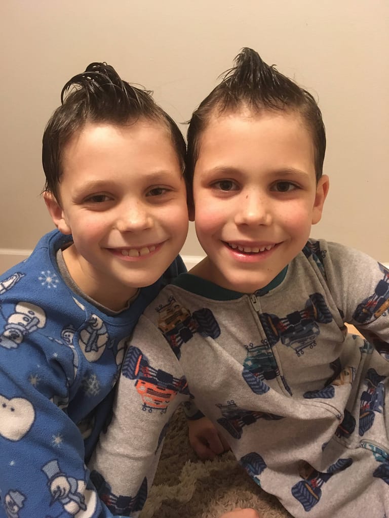 Two brothers with similar hairdos looking like twins.