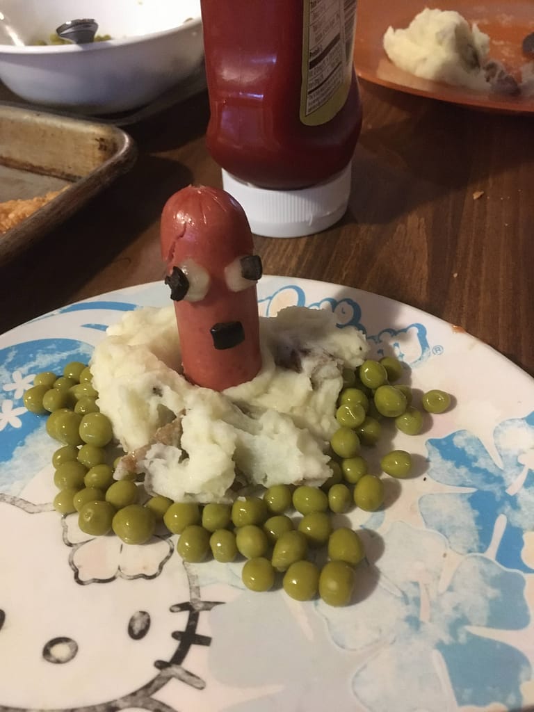 groundhog hot dog in mashed potatoes and peas