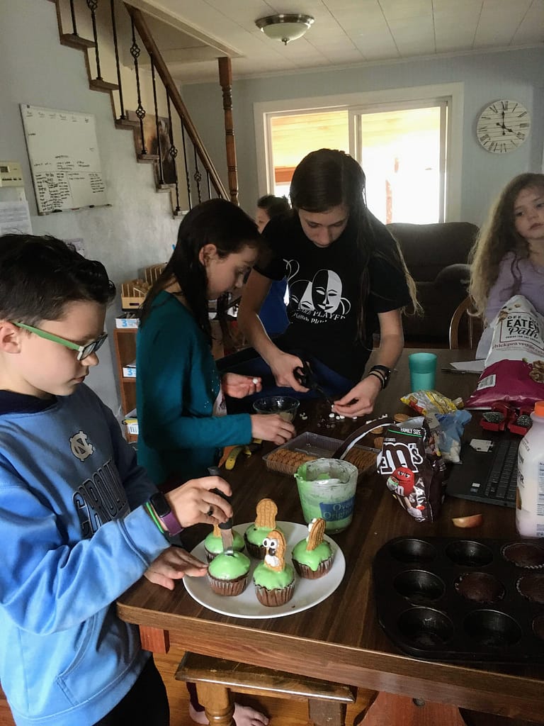 4 children assembling groundhog cupckaes