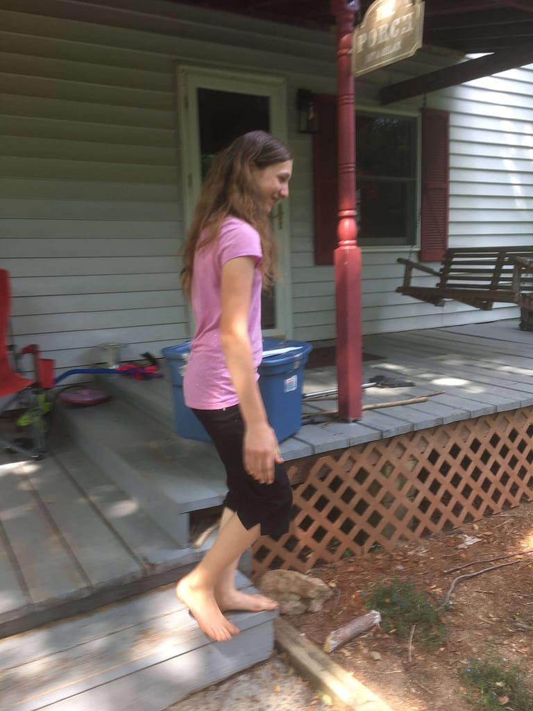 girl standing on steps of front porch