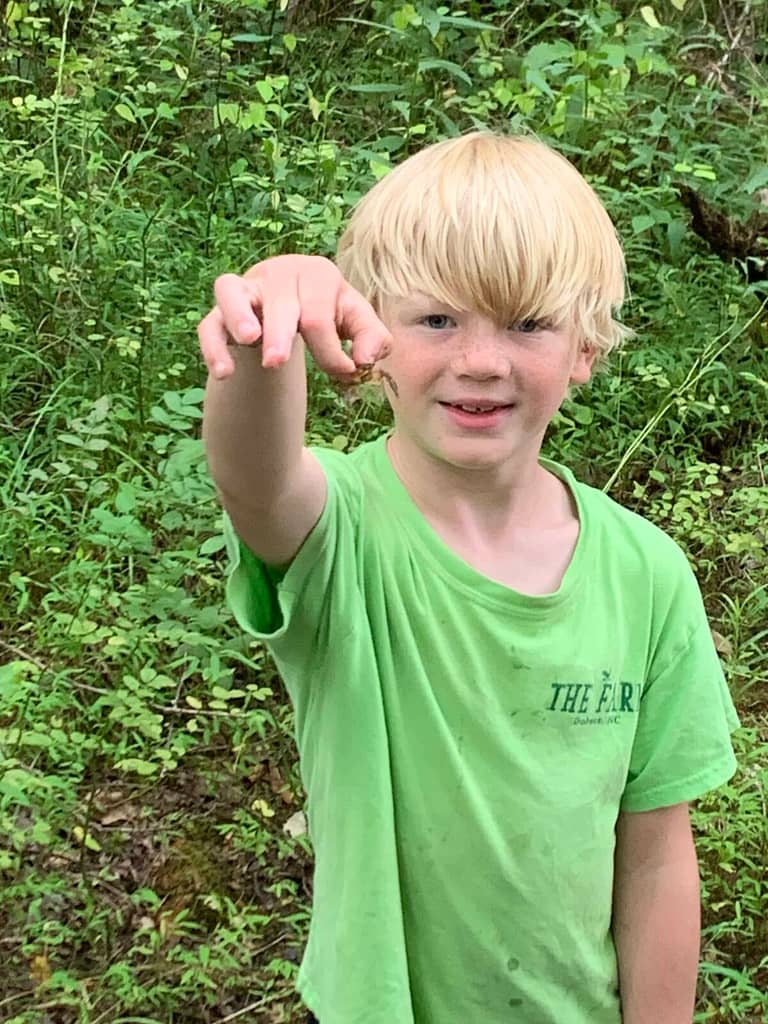 boy holding up a crawdad
