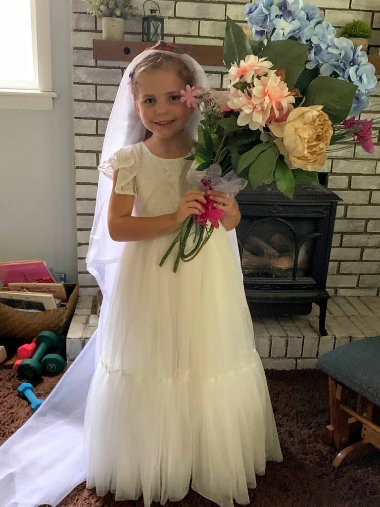a 6 year old playing wedding with a fancy white dress on