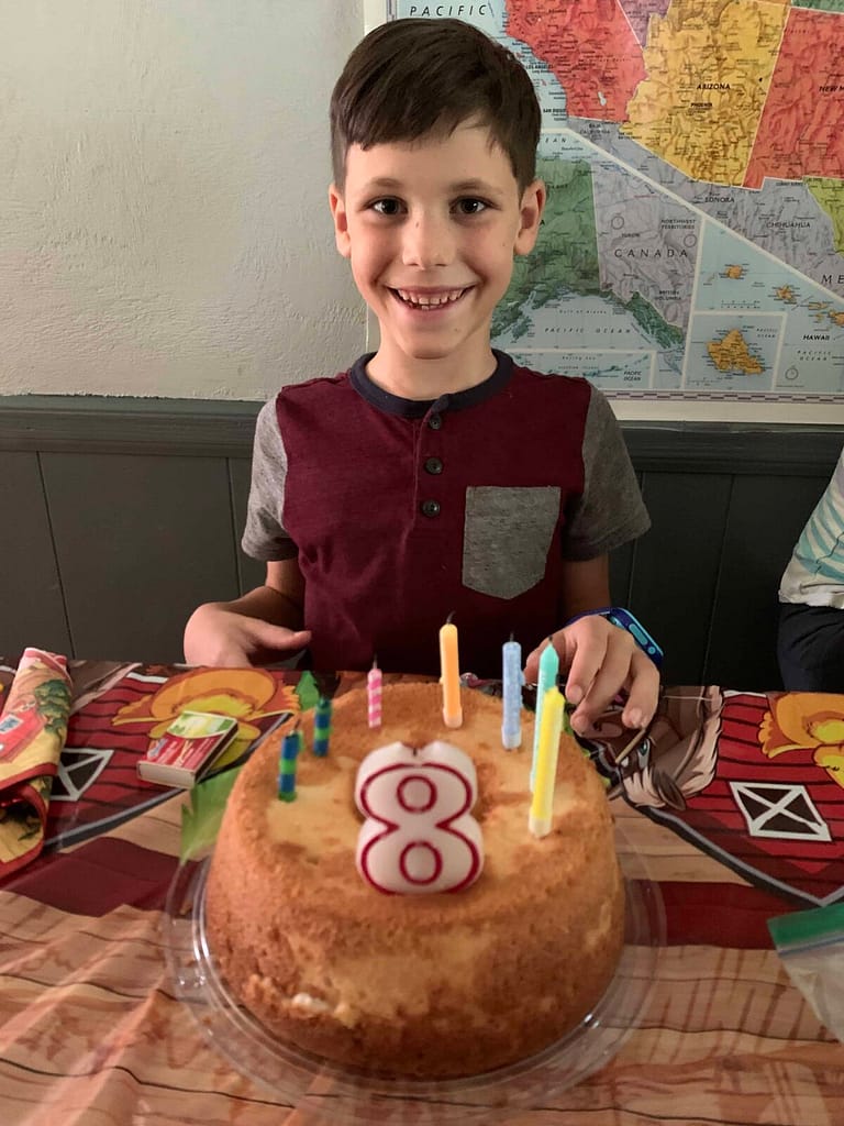 boy blowing out his candles on his 8th birthday
