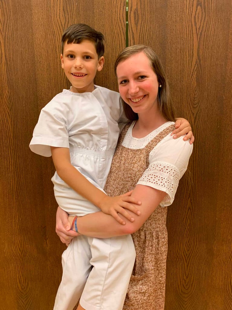sister and brother at brother's baptism