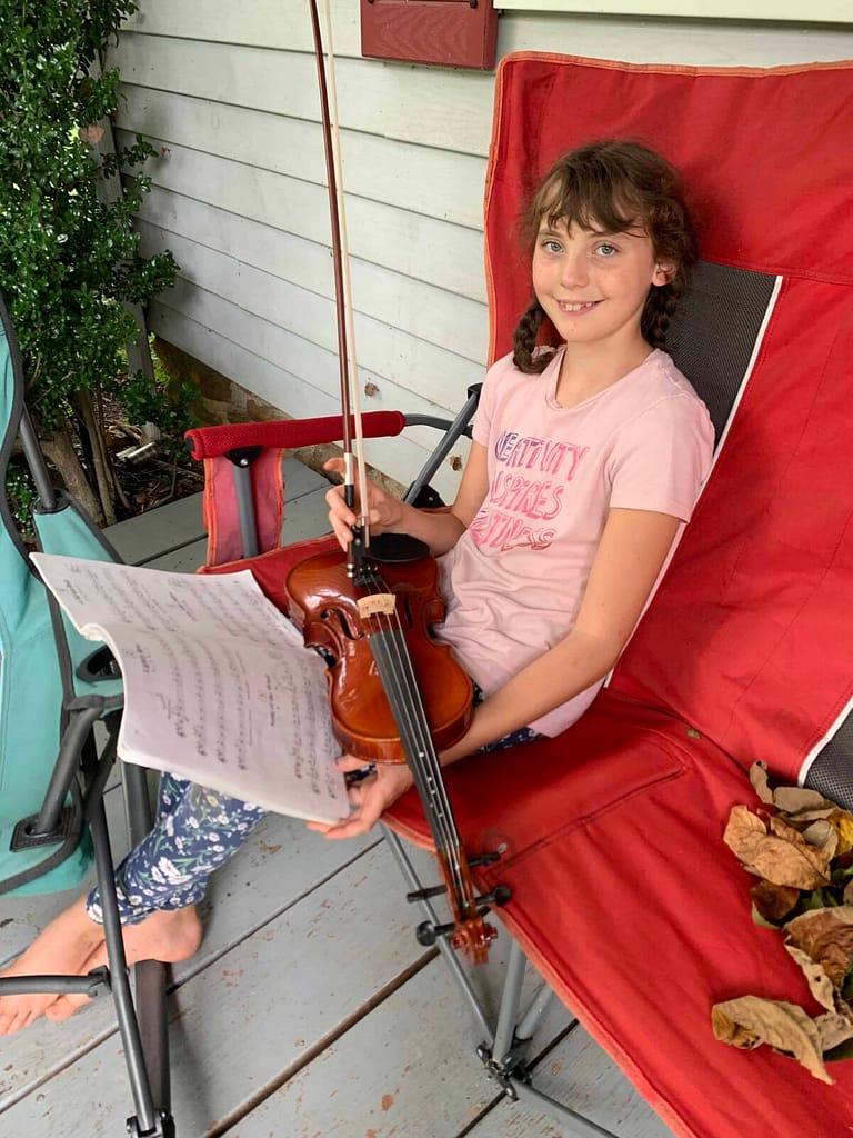 a 11 year old playing violin on the porch