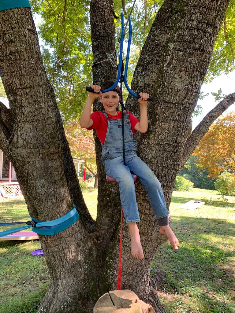 8 year old boy about to go on a zipline at his house