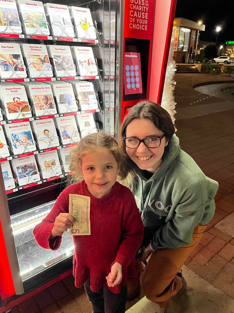 2 girls donating to light the world giving machine