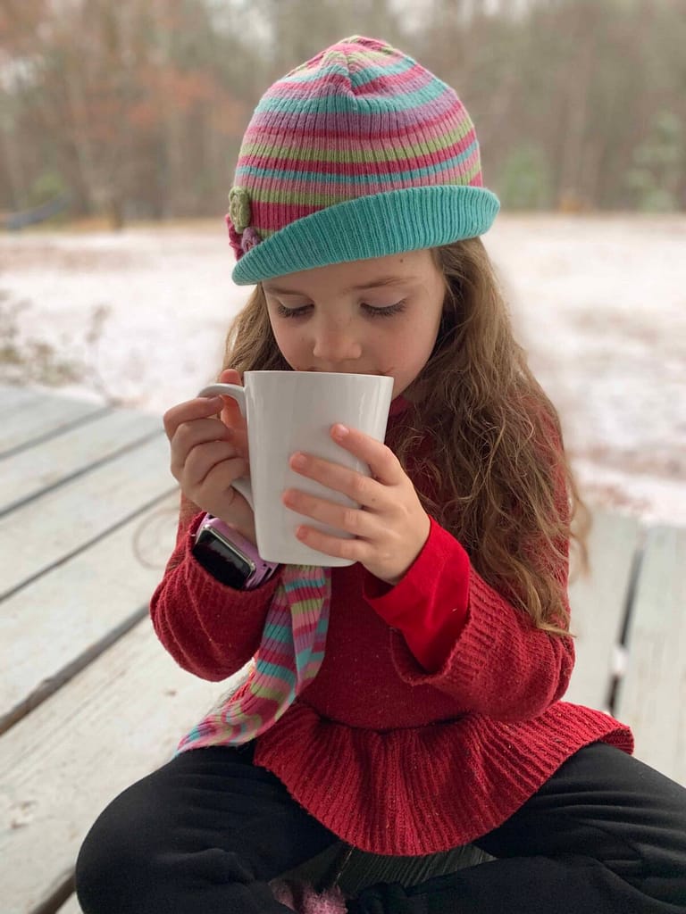 6 year old drinking hot chocolate in the snow