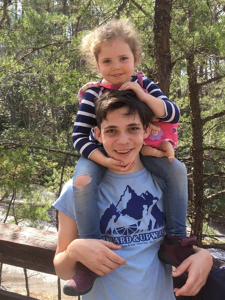 16 year old brother giving 6 year old sister a shoulder ride