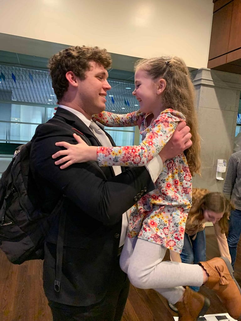 brother holding little sister at the airport