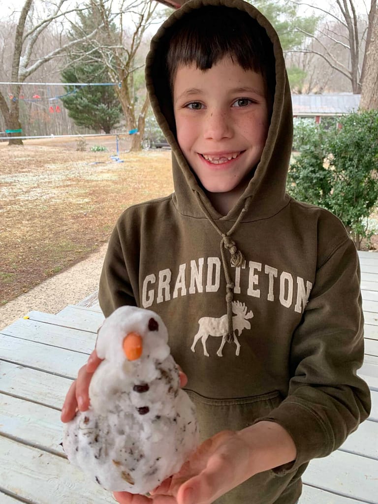 8 year old boy holding a tiny snowman