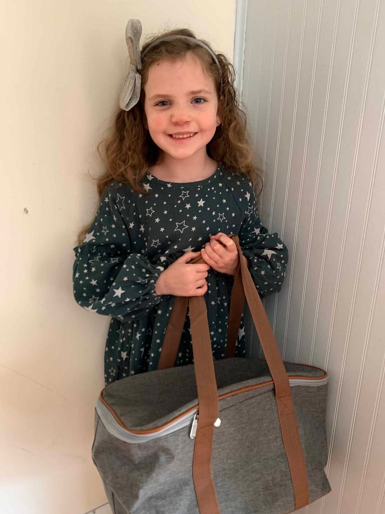 6 year old girl standing in corner with picnic basket