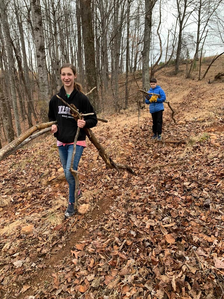 two kids hauling logs