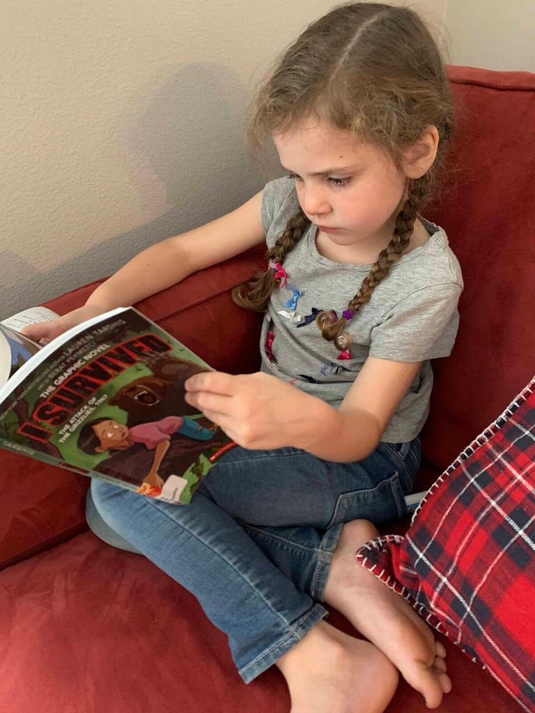 girl reading on red couch