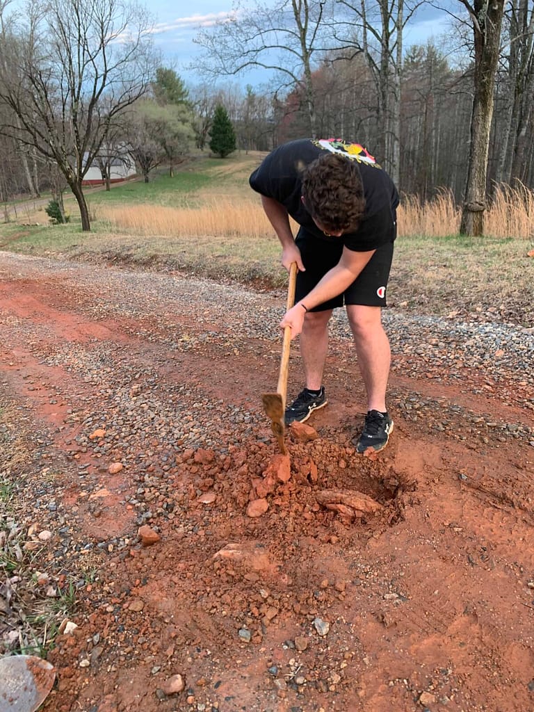 man working on a gravel driveway