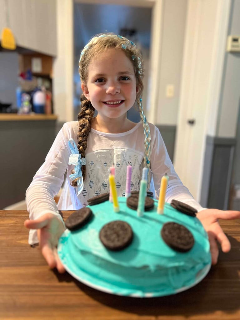 7 year old smiling with her birthday cake