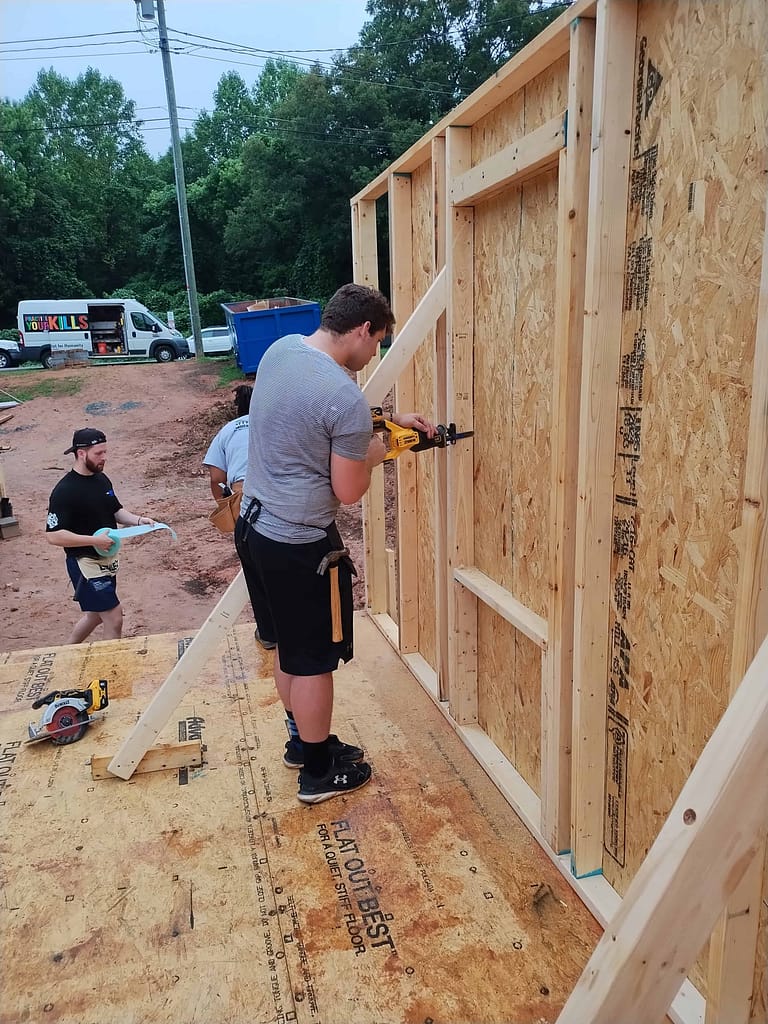 youth putting up a wall at habitat for humanity build
