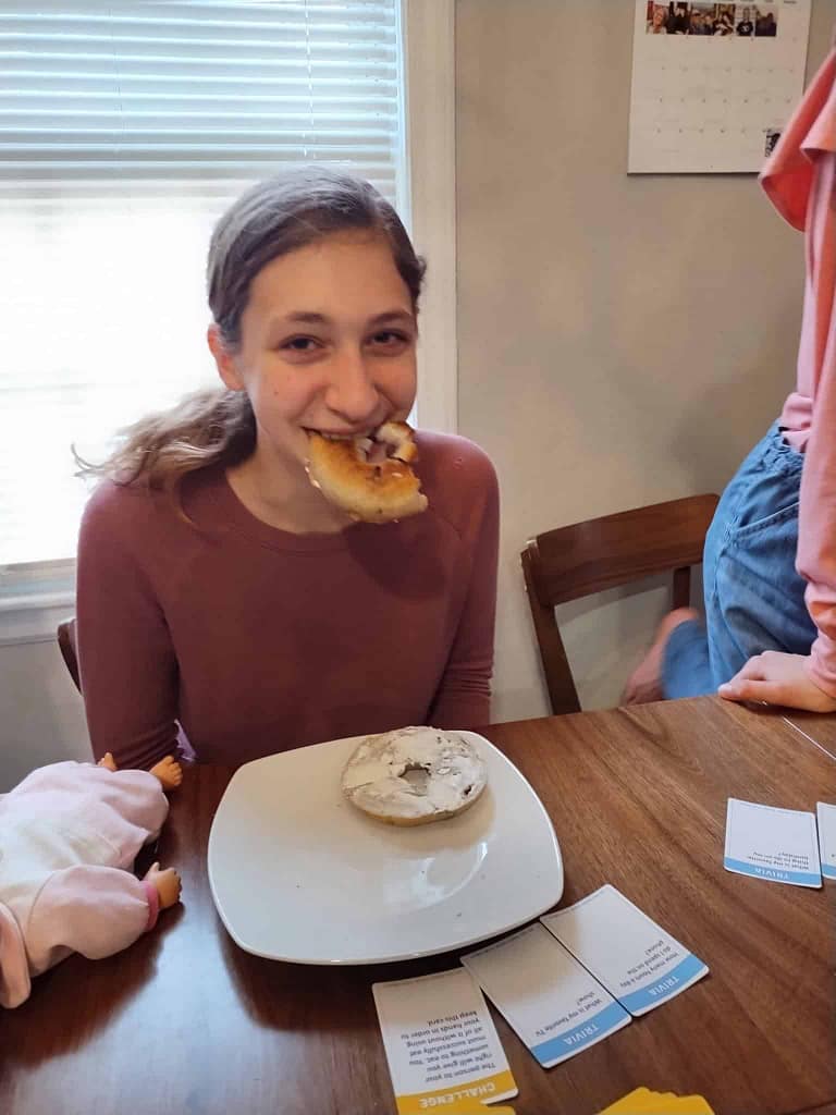 girl eating a bagel without hands