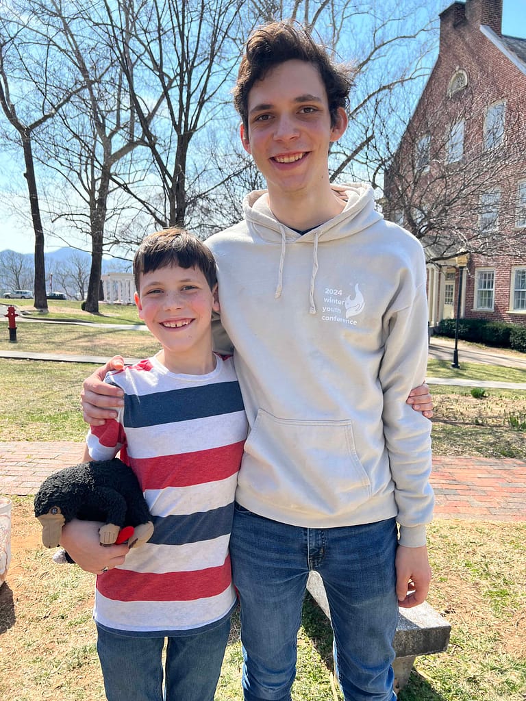 teen and younger brother hugging