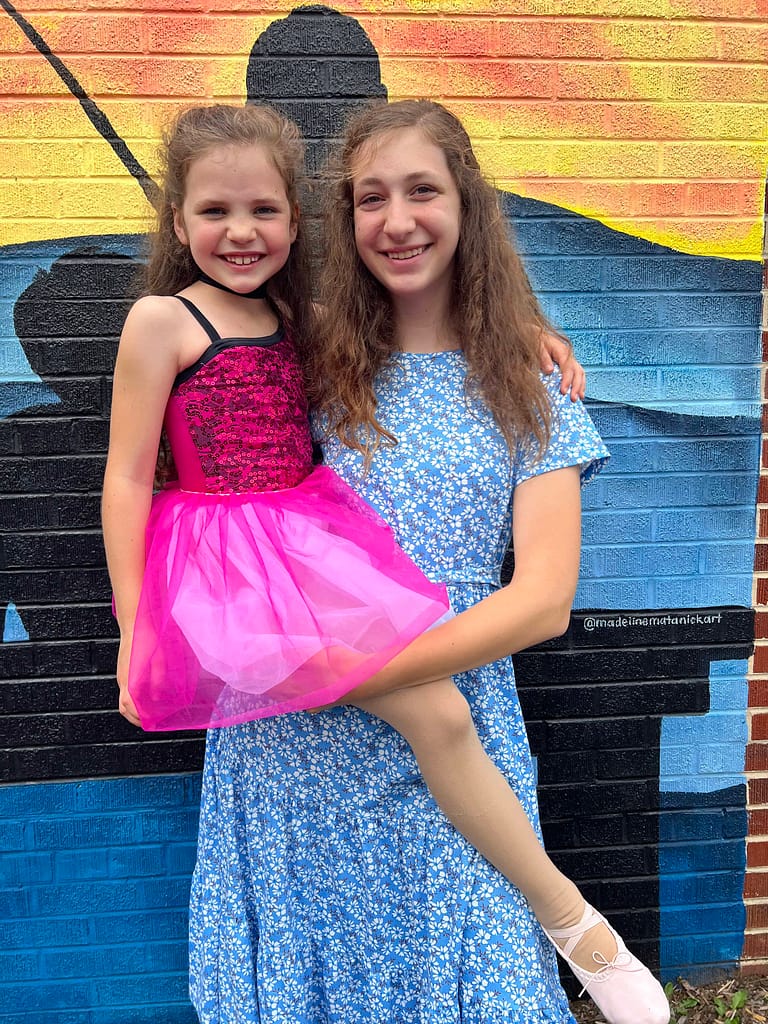 sister holding ballerina sister