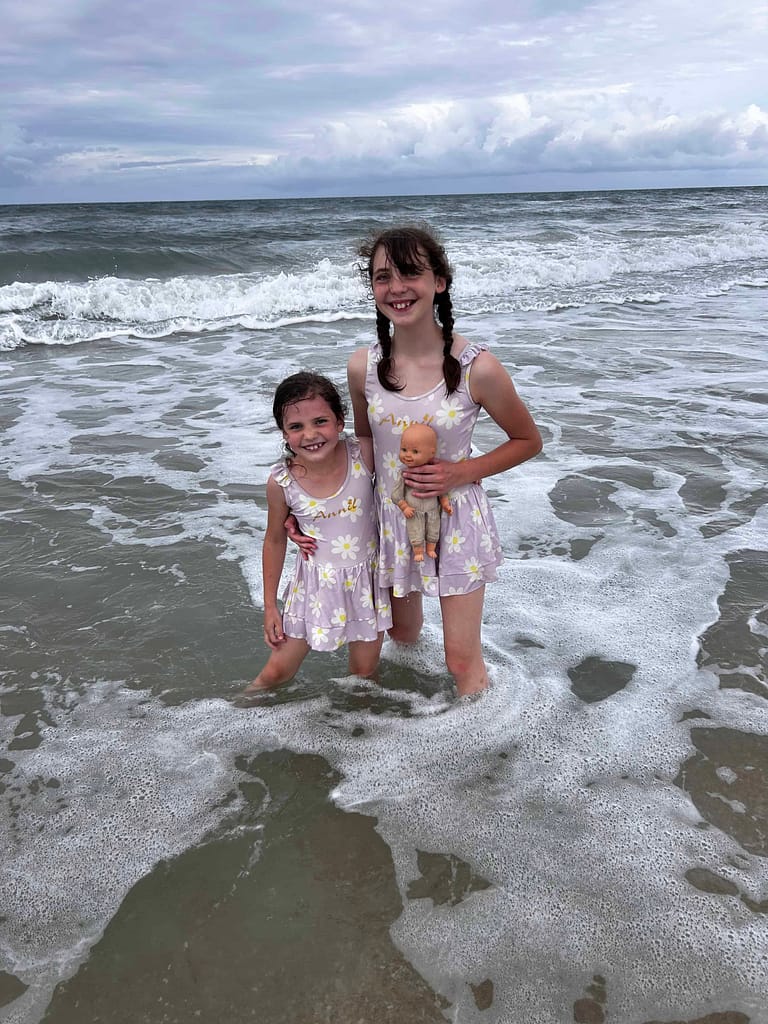two sisters with matching swimsuits in the ocean