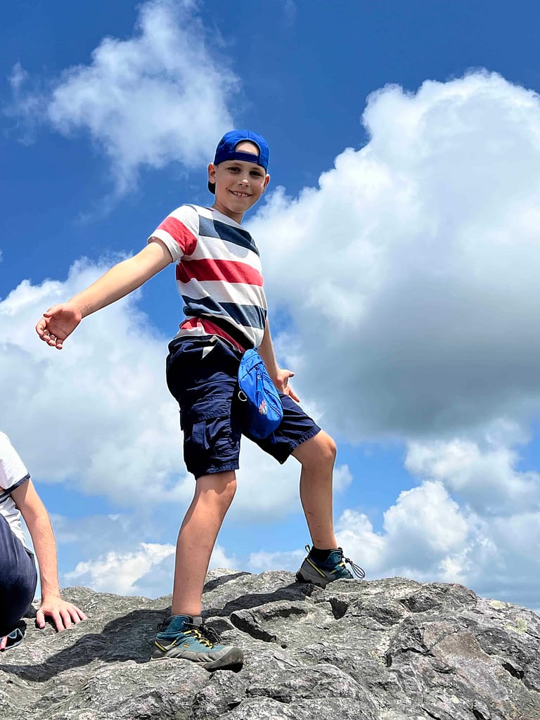 9 year old boy standing on top of a boulder