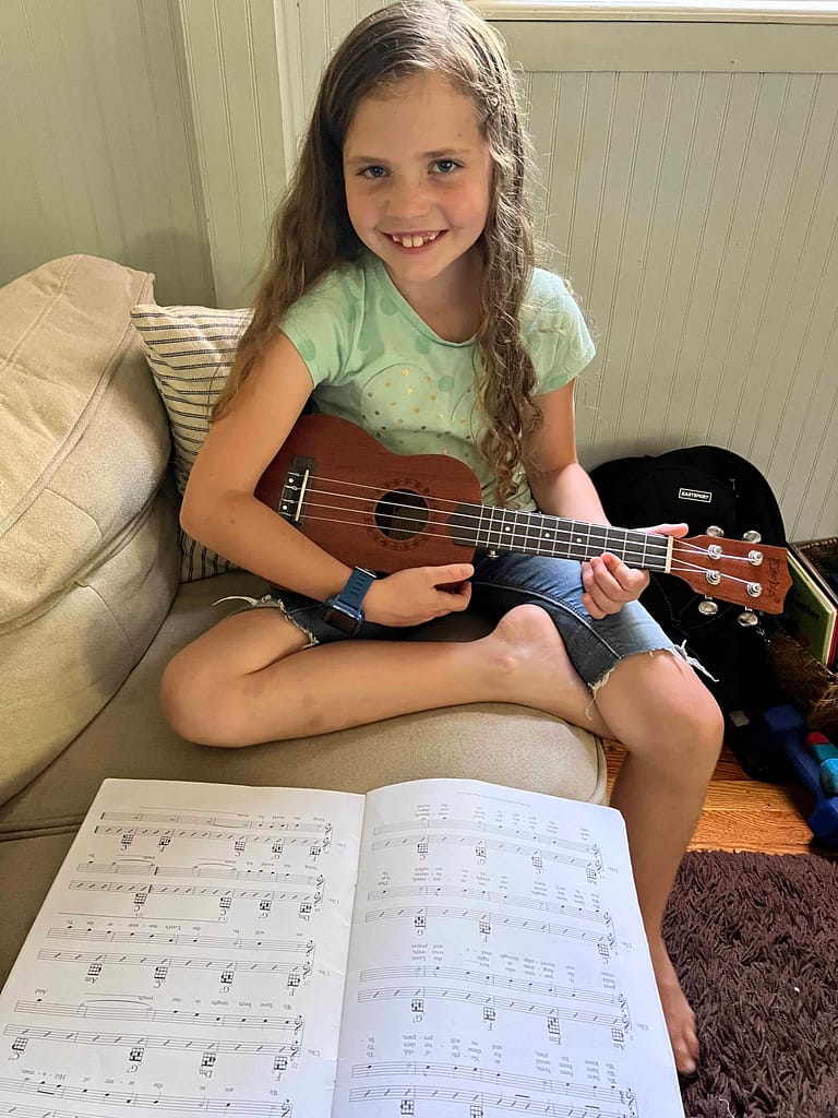 7 year old girl playing the ukulele