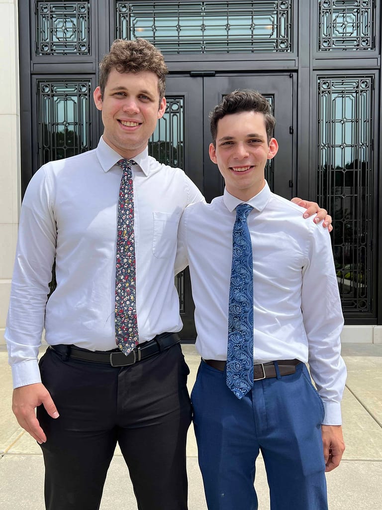 two young adult brothers in white shirts at the temple