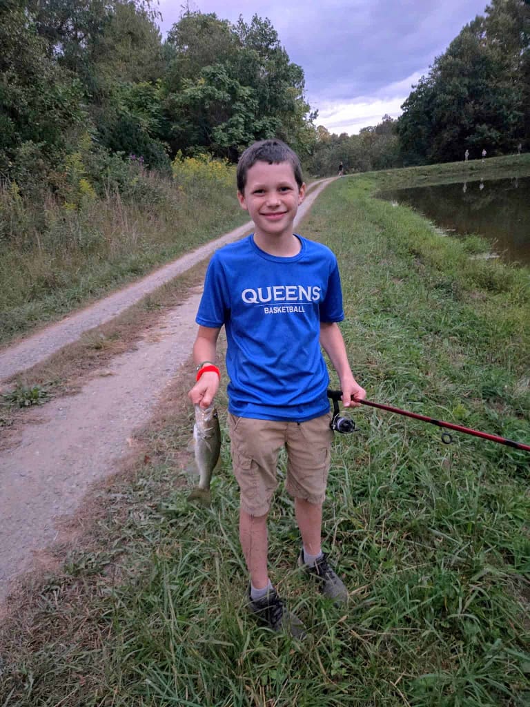 boy holding fish he caught