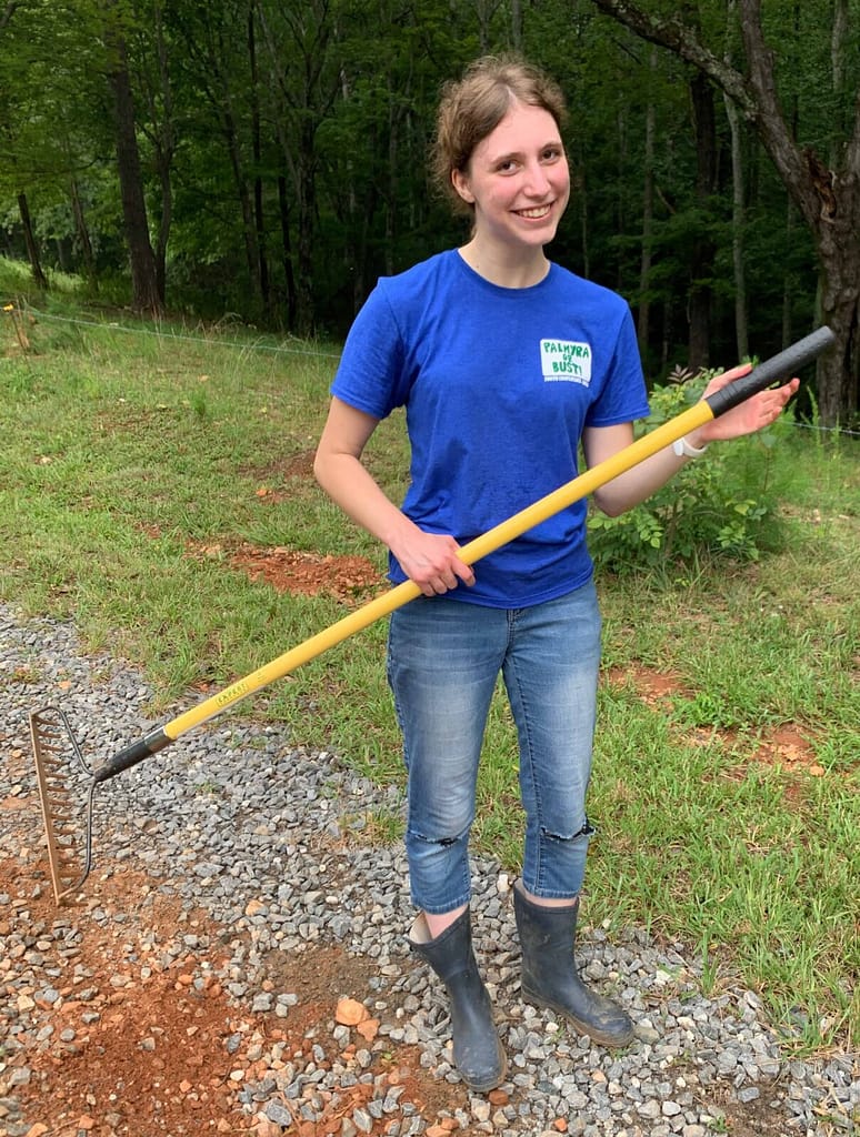 teen girl dancing with rake in driveway