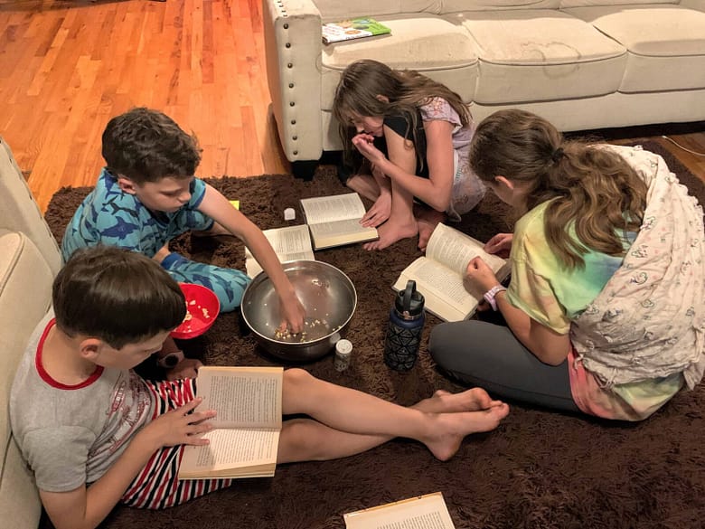 5 kids reading books and eating popcorn