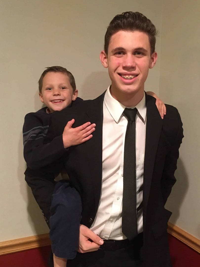 older brother gives younger brother piggyback