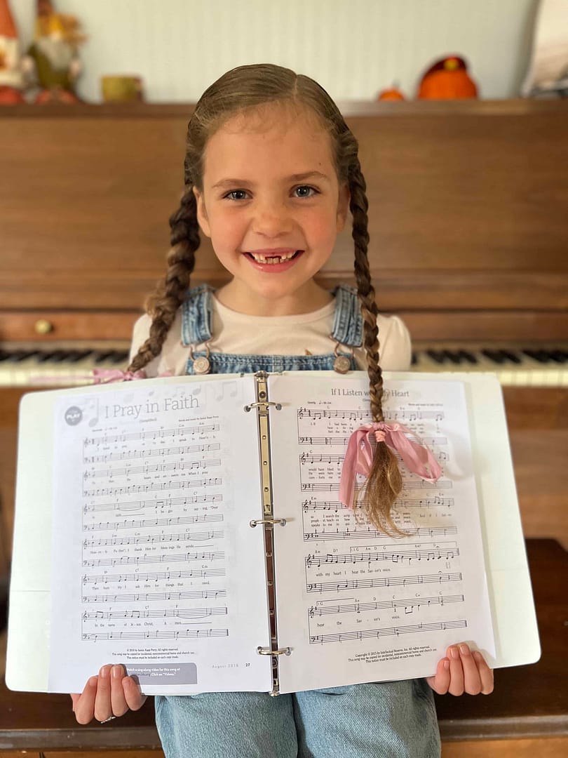 7 year old showing songbook she made