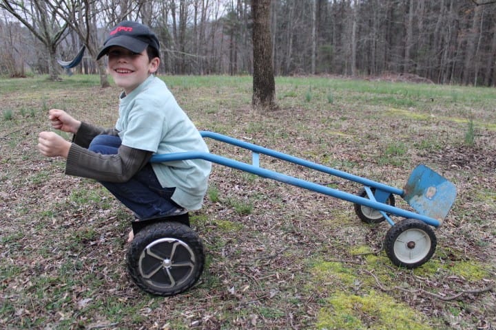 boy on hoverboard pulling a dolley