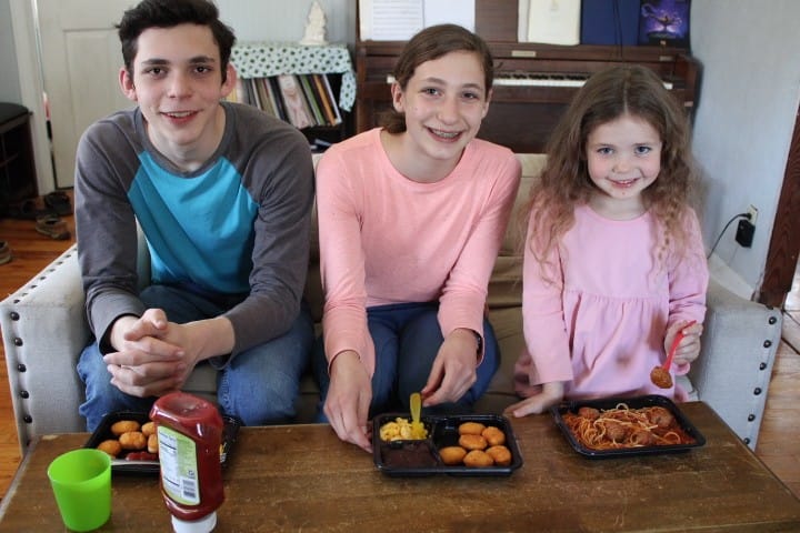 3 kids eating TV dinners