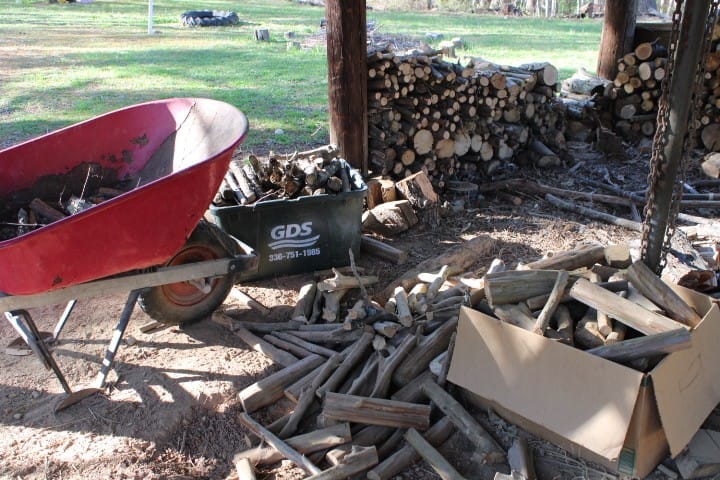 piles of wood scattered around the wood shed.