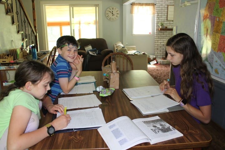 3 kids studying at the table together